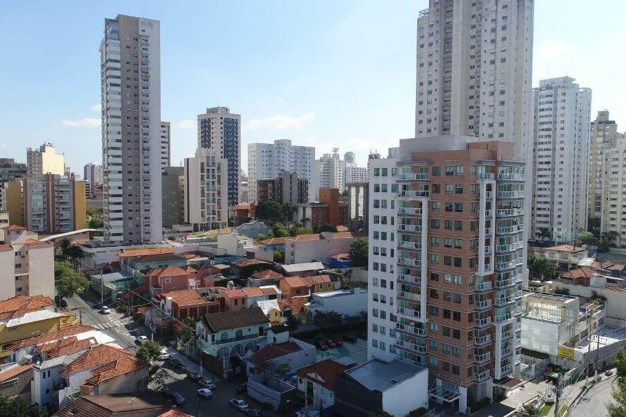 Rua arborizada da Chácara Klabin, com prédios residenciais ao fundo