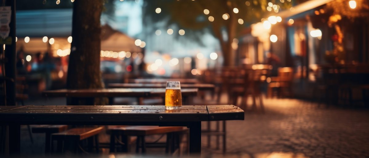 Mesas de bar na calçada em Pinheiros, ao anoitecer
