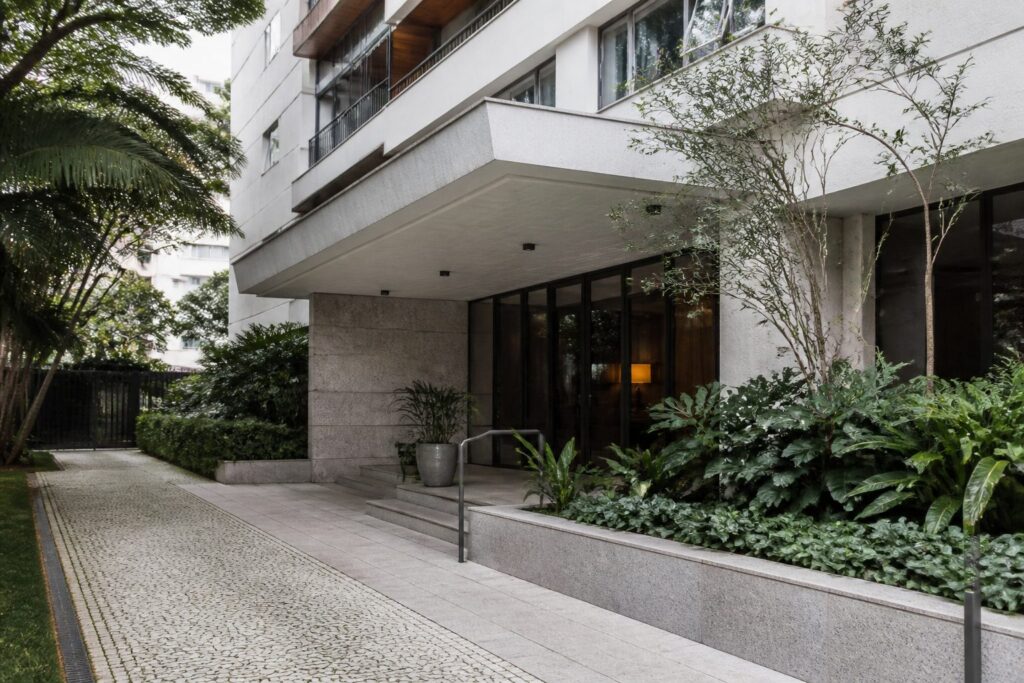 Fachada de edifício residencial concluído, com paisagismo no acesso